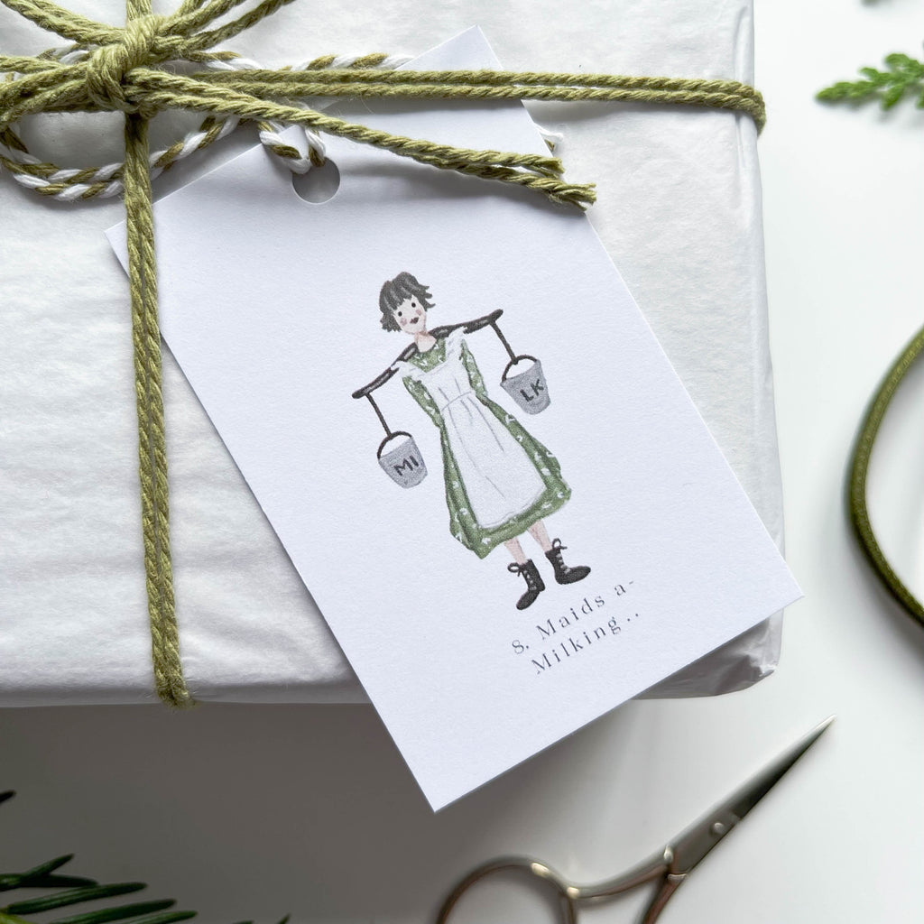 eight maids a milking hand illustrated 12 days of christmas gift tag on box with green string