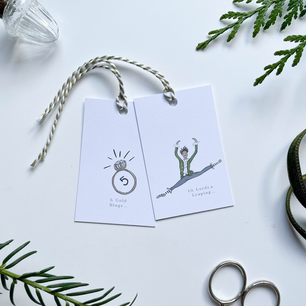 5 gold rings & leaping lords gift tag with hand illustrated 12 days of christmas characters strung with stripey bakers twine